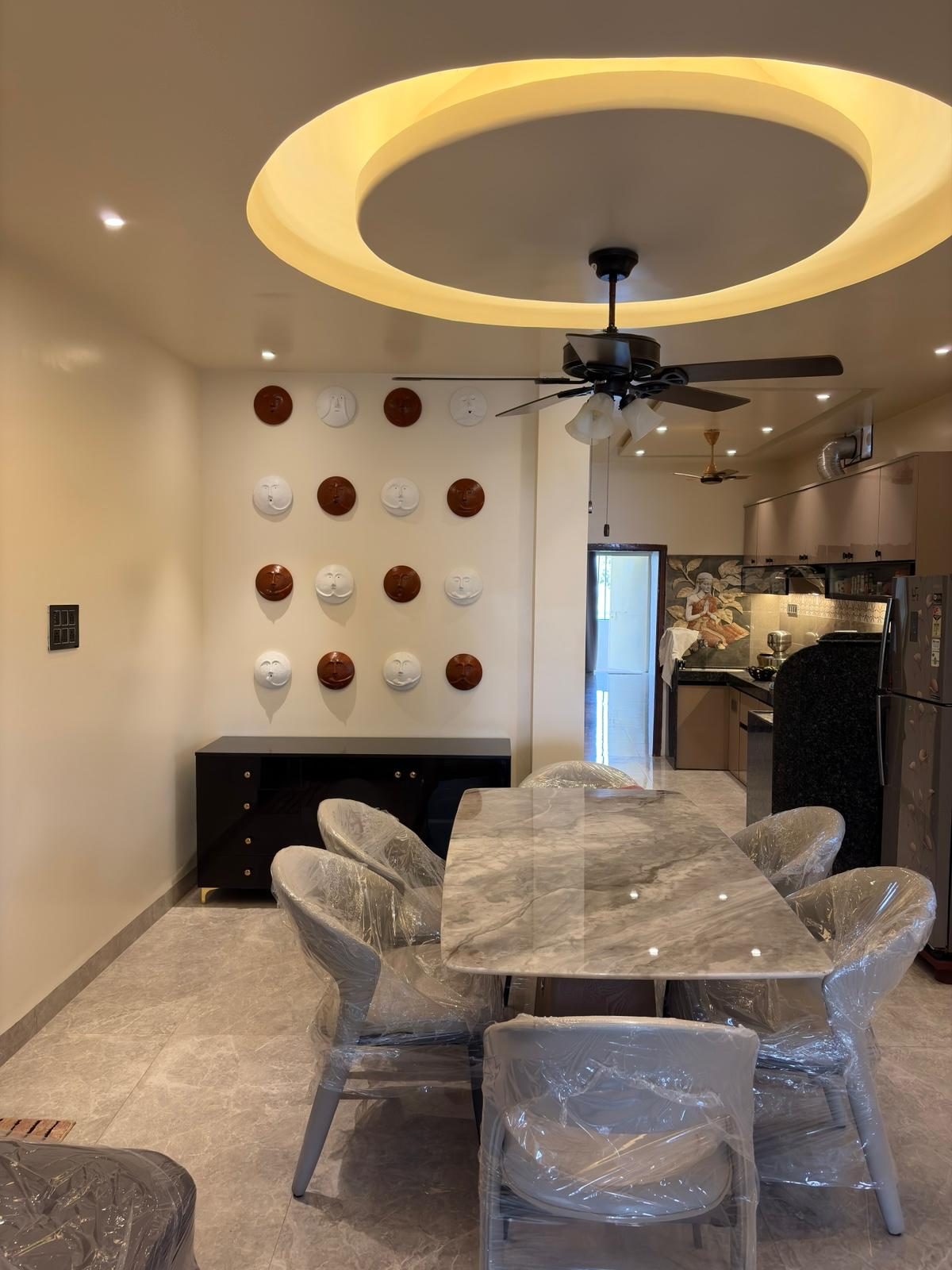 Dining area of Shubhasheesh, with the plate wall and open kitchen beyond